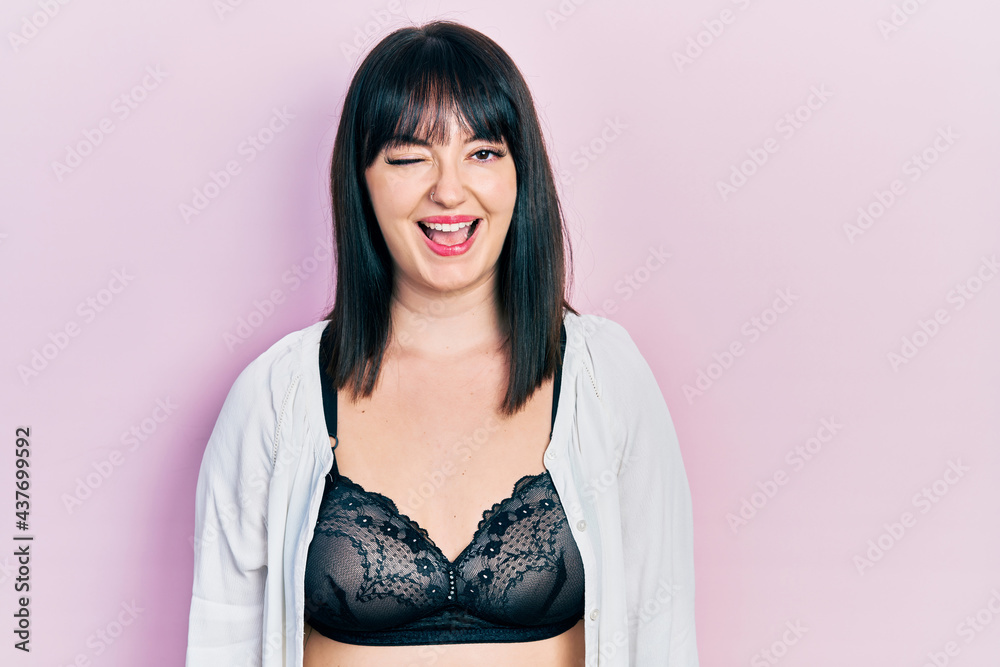 Canvas Prints Young hispanic woman wearing lingerie winking looking at the camera with sexy expression, cheerful and happy face.