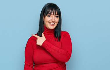 Fototapeta premium Young hispanic woman wearing casual clothes cheerful with a smile of face pointing with hand and finger up to the side with happy and natural expression on face
