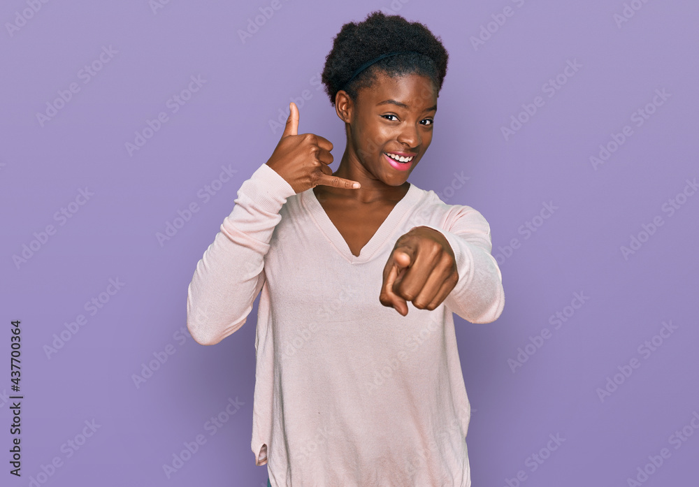 Canvas Prints Young african american girl wearing casual clothes smiling doing talking on the telephone gesture and pointing to you. call me.