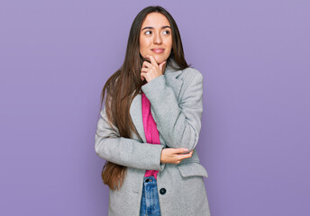 Young hispanic girl wearing business clothes with hand on chin thinking about question, pensive expression. smiling with thoughtful face. doubt concept.