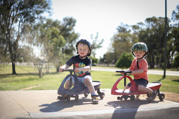 Happy little boys playing on rode on carts at skate park