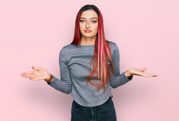 Young caucasian woman wearing casual clothes clueless and confused expression with arms and hands...
