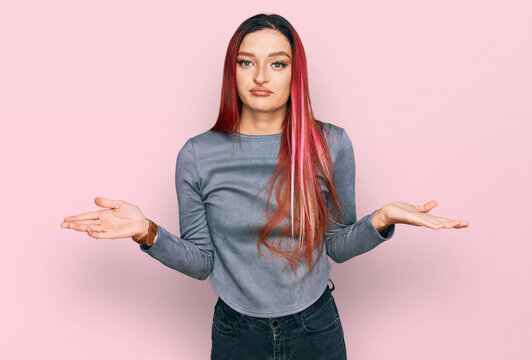 Young caucasian woman wearing casual clothes clueless and confused expression with arms and hands raised. doubt concept.