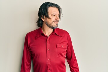 Middle age handsome man wearing casual clothes looking away to side with smile on face, natural expression. laughing confident.