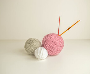 pastel woolen balls on withe ground with colorful crochet hooks