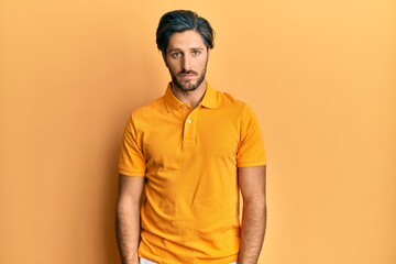 Young hispanic man wearing casual yellow t shirt depressed and worry for distress, crying angry and afraid. sad expression.