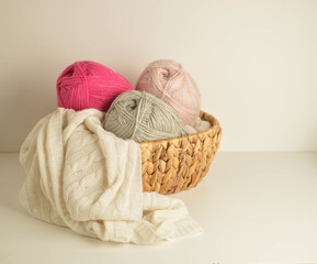 Fototapeta na wymiar soft colored woolen balls in basket with white woolen blanket