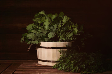 wooden tub with bath brooms on a bench in a traditional steam sauna banya