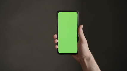 POV top view shot of man hold phone with green screen indoor