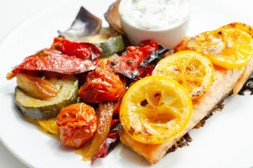 Grilled salmon fillet served with roasted vegetables with cucumber and dill sauce