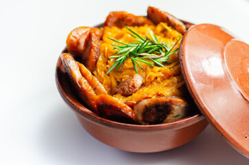 Traditional Polish dish called bigos made of sauerkraut, sausage and mushrooms, food served warm in a ceramic bowl