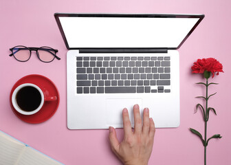 Top view with hand on laptop and coffee cup, red flower, glasses