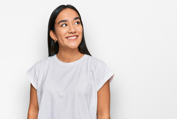 Young asian woman wearing casual white t shirt looking away to side with smile on face, natural...