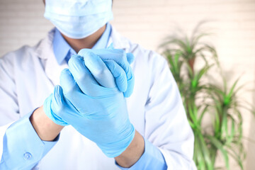 Fototapeta premium man doctor wears medical gloves, close up