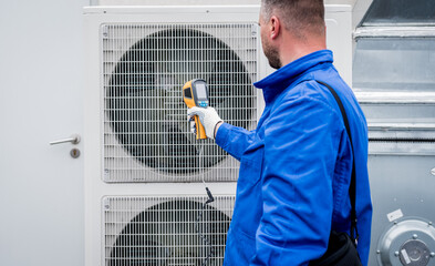 Technician uses a thermal imaging infrared thermometer to check the condensing unit heat exchanger.