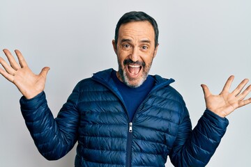 Middle age hispanic man wearing casual clothes celebrating victory with happy smile and winner expression with raised hands