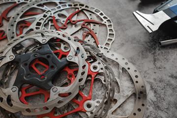 Worn mountain bike brake discs lying in the workshop next to the disc straightening tool (rotor...