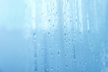 Naklejka na ściany i meble raindrops on glass window on cloudy day selective focus