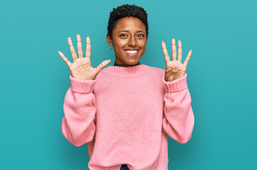 Young african american woman wearing casual clothes showing and pointing up with fingers number...