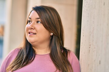 Young hispanic plus size woman smiling happy standing at the city.