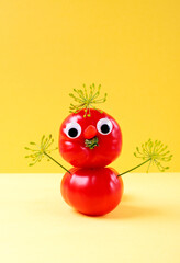 Funny man made of imperfect tomatoes against the yellow background. Cute food craft for kids. Food...