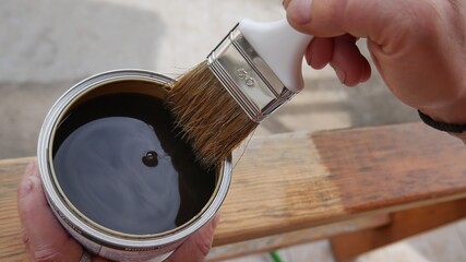 hand of wood professional painting with impregnating agent, for wood a brown