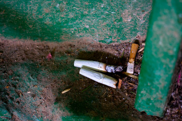 Photos of the remains of cigarettes, that is, cigarette butts in the entrance. Pollution.
