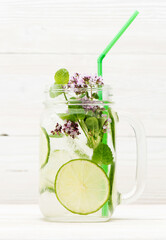 Summer infused detox.cold waters with lime mint on white wooden background