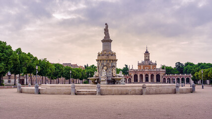 Fototapeta na wymiar Square and fountain of royal palace with statue in cloudy day at sunset. Aranjuez Madrid.