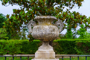 Royal palace garden with detail of ancient stone vase sculpture.
