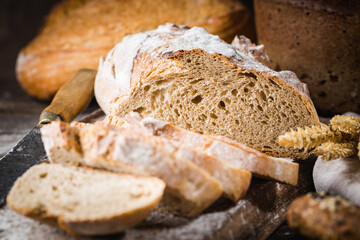 Fresh homemade slice bread and knife on rustic table