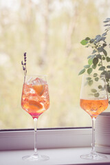 Aperol spritz cocktail with ice in glass on on the windowsill