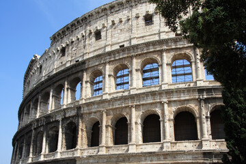 Scenic view of the Roman Coliseum (Colosseum) against the blue sky on a summer sunny day. Rome, Italy. Close-up