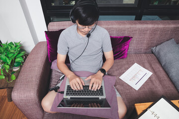 Businessman meeting online via video call on laptop in home office. Man wear headphone video calling or distance education e-leaning online course.