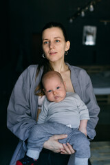mother holds the baby in her arms and breastfeeds