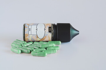 Pills of herb capsule with pill bottle on white background.