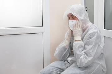 Exhausted doctor in protective medical clothing during the coronavirus epidemic.