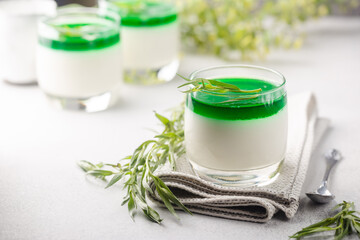 Dessert Panna Cotta with green tarragon sauce and fresh tarragon on white background