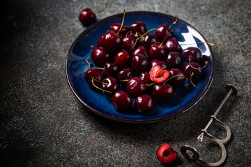 Fresh ripe cherry on blue plate close up
