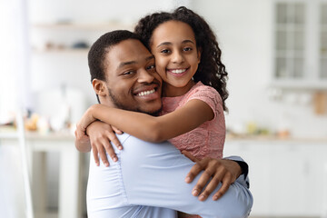 Adorable black family father and daughter hugging, copy space