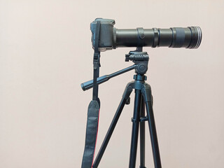 Super telephoto lens zoom on the tripod with DSLR camera horizontal photography isolated on cement...