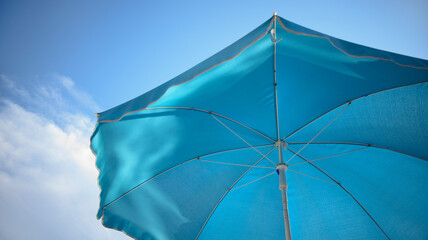 Blue beach unbrella on the sky background