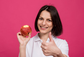 Beautiful young woman hold a big apple in her hand