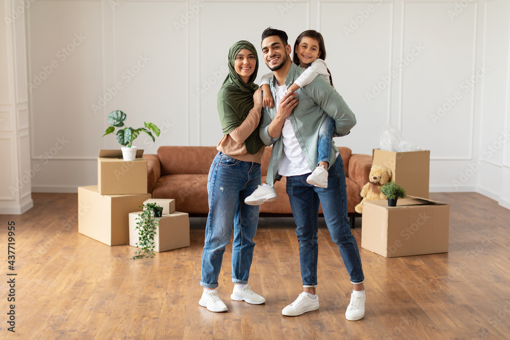 Poster happy muslim family looking at camera, posing on moving day