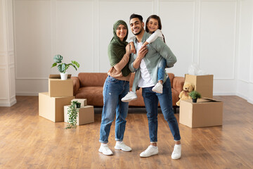 Happy muslim family looking at camera, posing on moving day