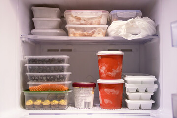 Full of frozen food in refrigerator. Meat, fish, fruit, chocolate, ice and bucket container ice...