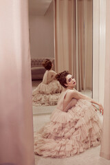 Young lady white caucasian woman with hairstyle in rose pink wedding dress posing on a pink classic sofa - 437727152