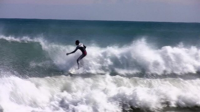 Surfer against big wave in Mediterranean sea