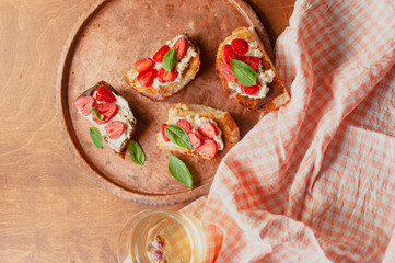 Strawberry toast brioche with cream cheese decorated with flowers and basil fflat lay close up