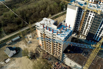 Fototapeta premium Construction and construction of high-rise buildings, the construction industry with working equipment and workers. View from above, from above. Background and texture